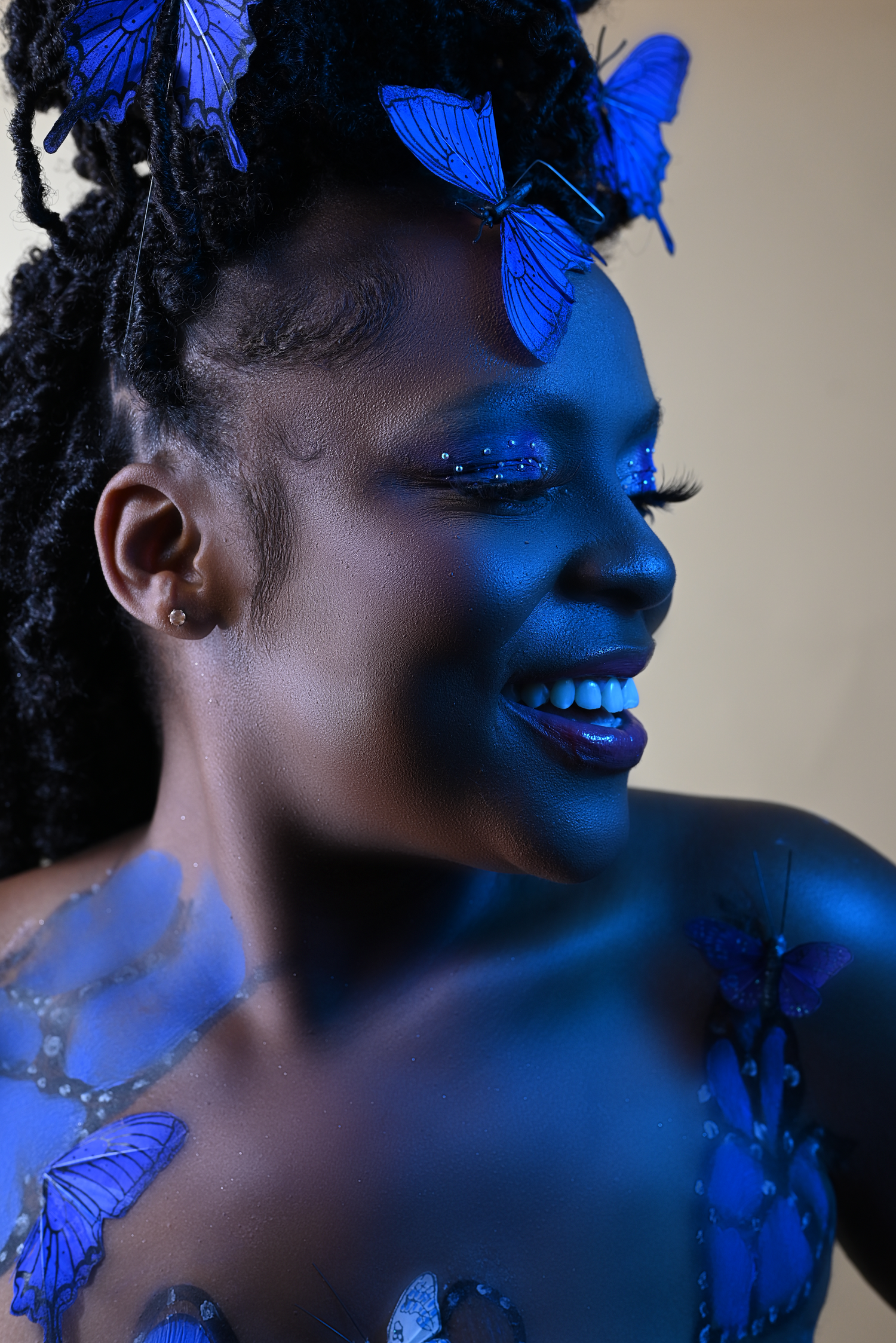 Moody portrait with blue butterfly accents and dramatic shadows.