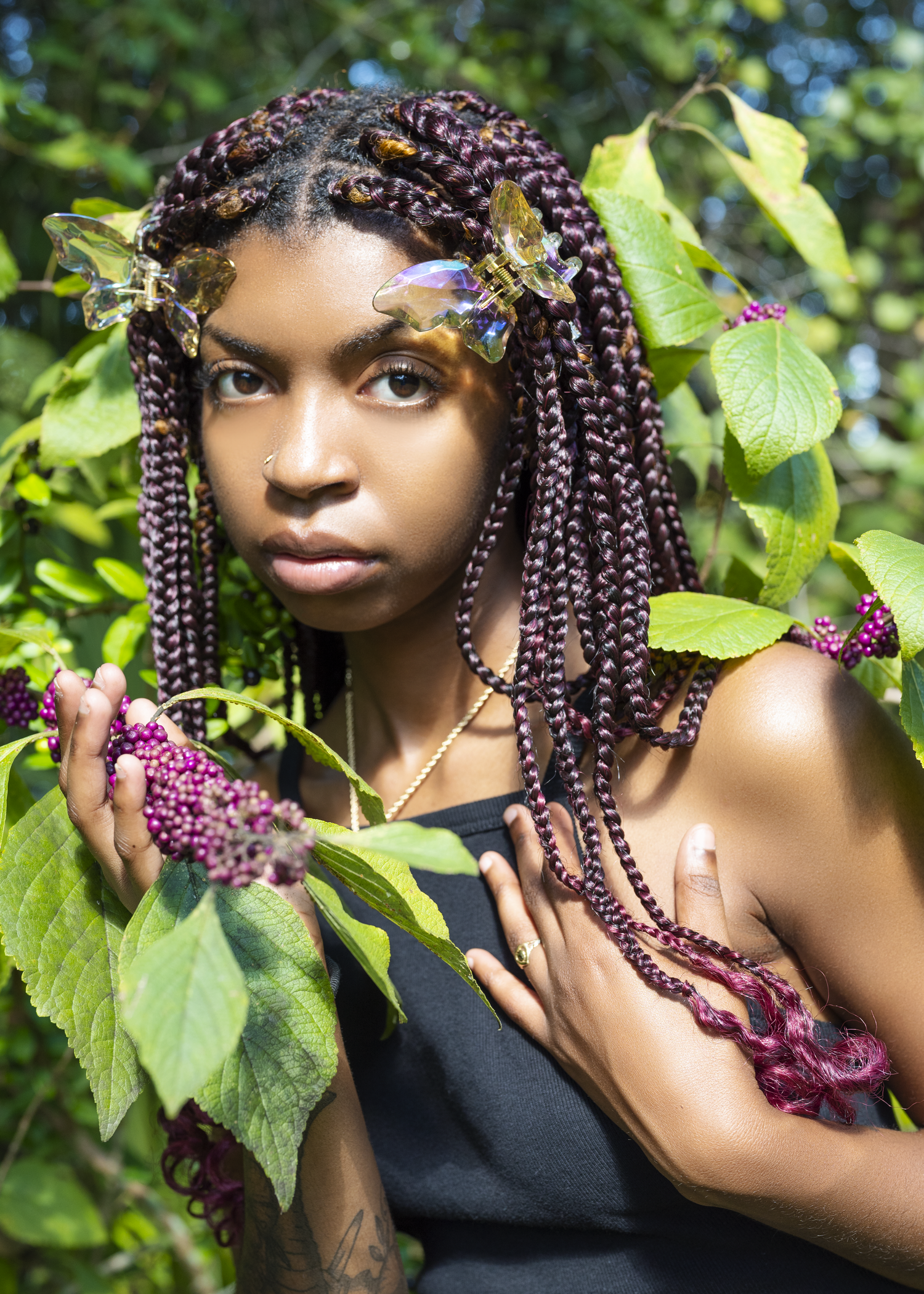 Outdoor portrait among grape vines with burgundy braided hair.