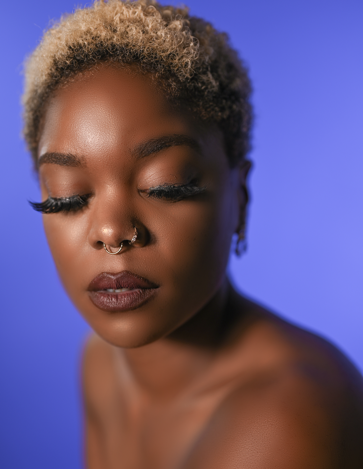 Close-up beauty portrait with blonde hair against blue background.