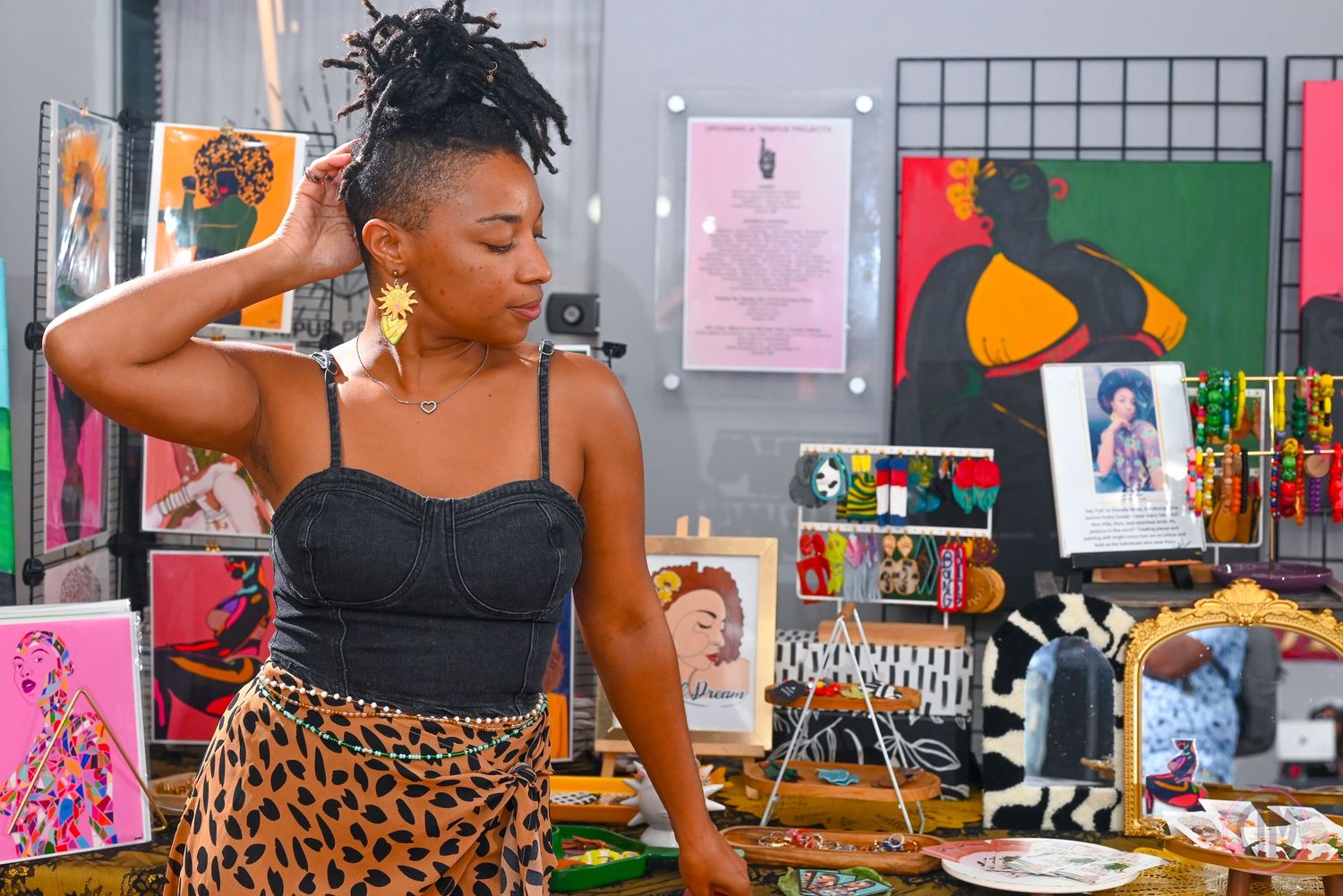 Colorful art displays and vendor booths set up along indoor gallery wall.