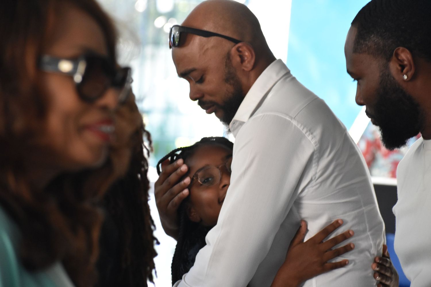 A close-up view of people embracing during an emotional church moment.