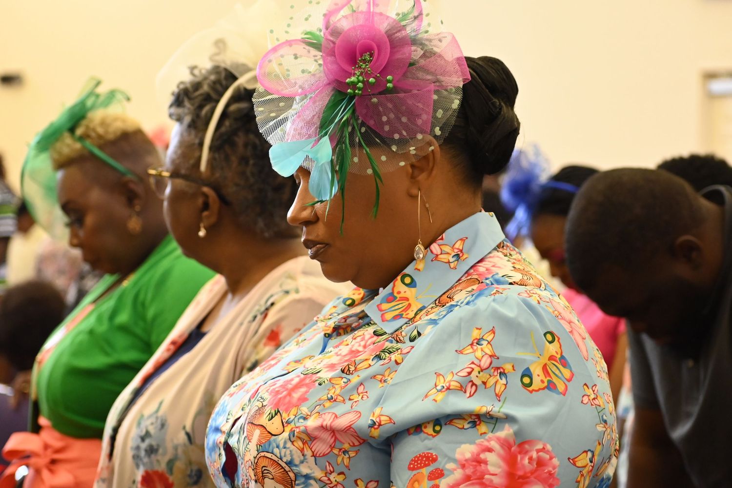Church attendees wearing colorful floral and polka dot patterns during a service.