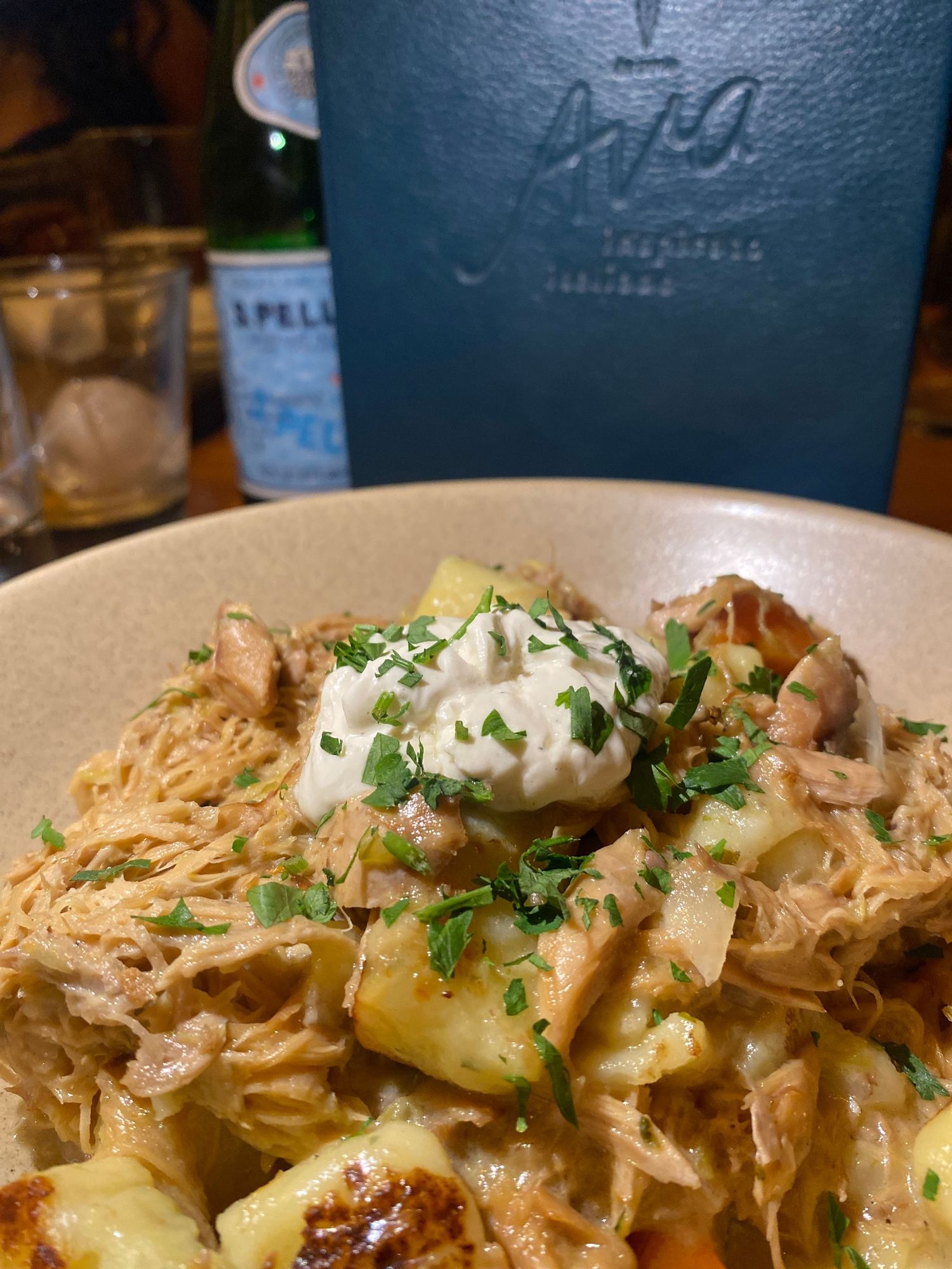 Creamy pasta dish with potatoes and herbs topped with a dollop of sauce.