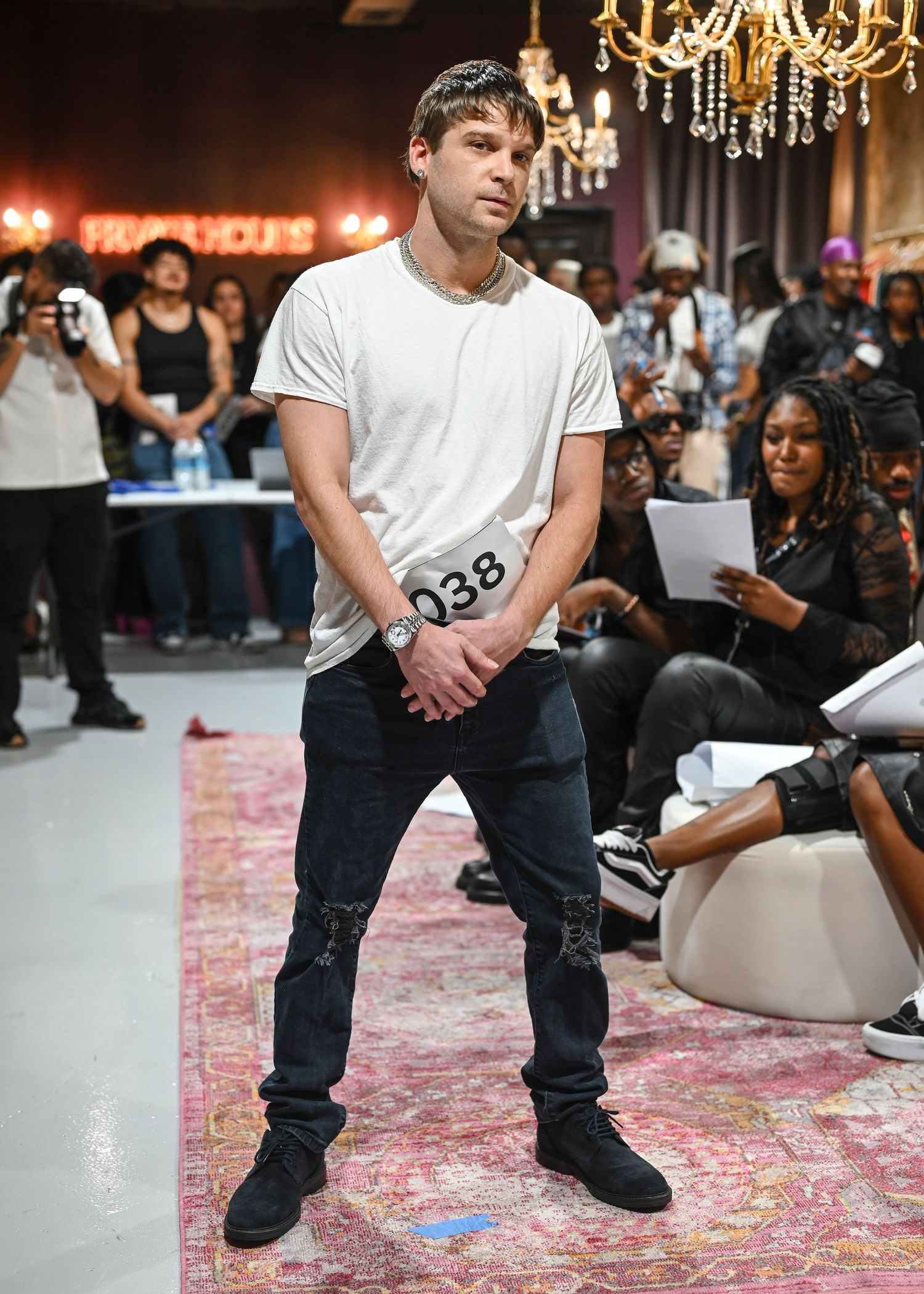 Models demonstrate poses in dark denim during a fashion show presentation.