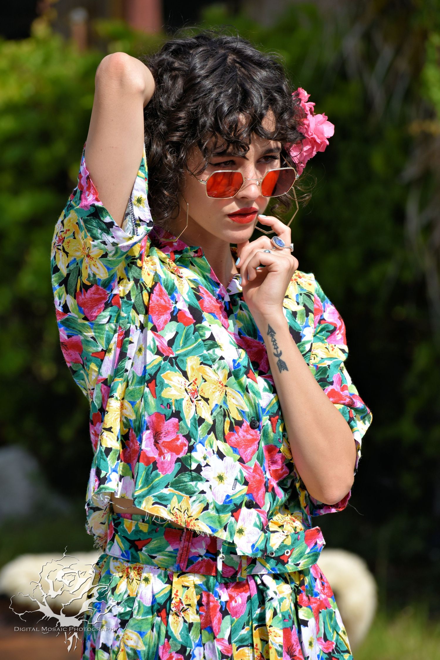 Floral print summer dress styled with sunglasses and accessories in an outdoor garden setting.