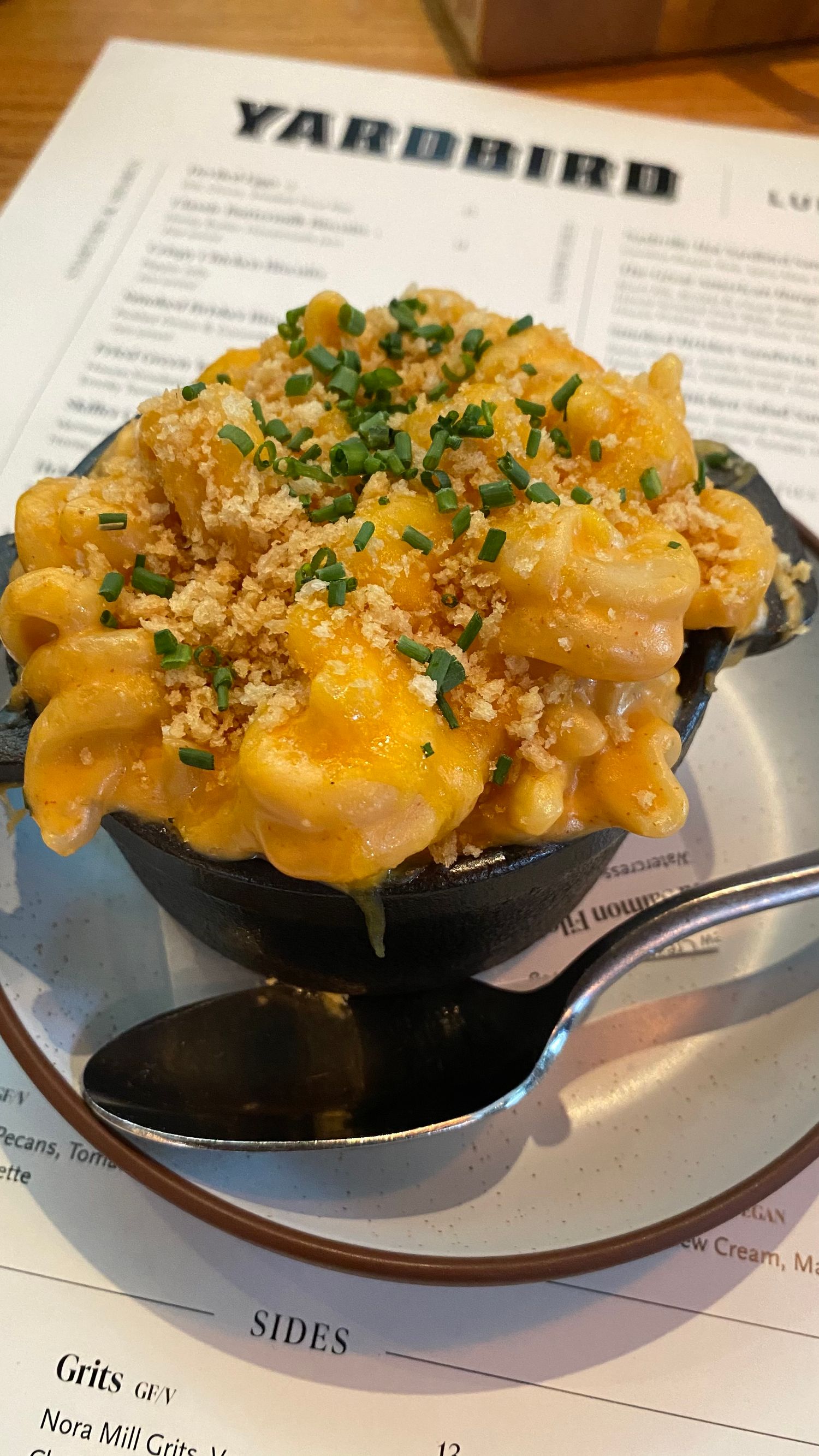 Creamy mac and cheese topped with breadcrumbs and herbs served in individual cast iron skillets.