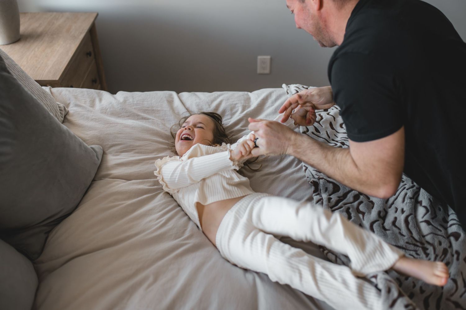 child and dad playing on bed, greenville, nc