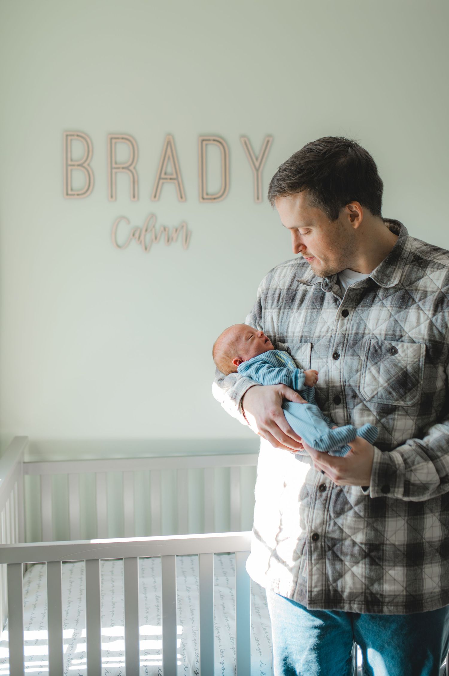 dad and baby standing in front of crib in nursery, greenville, nc, newborn photographer