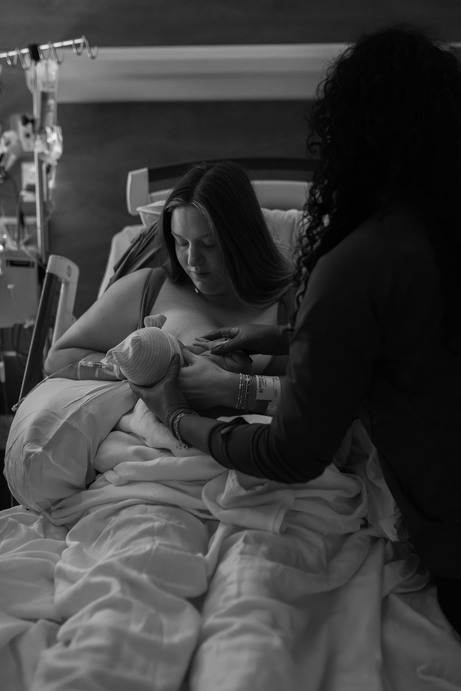 mom breastfeeding baby after birth in hospital at ECU Health Medical Center for the first time with nurse help