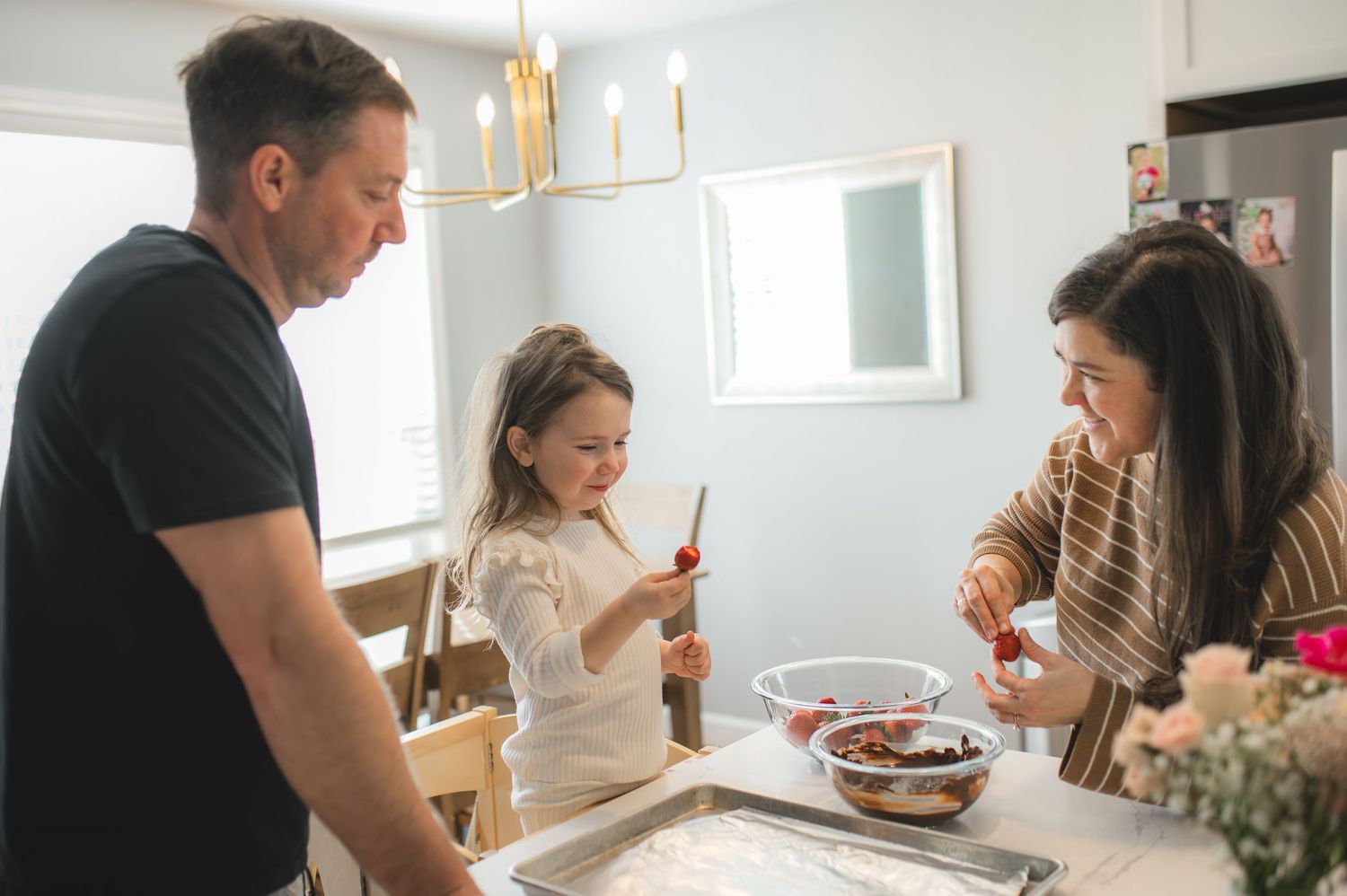 mom dad and child with baking tray and bowl of strawberries and chocolate, greenville, nc