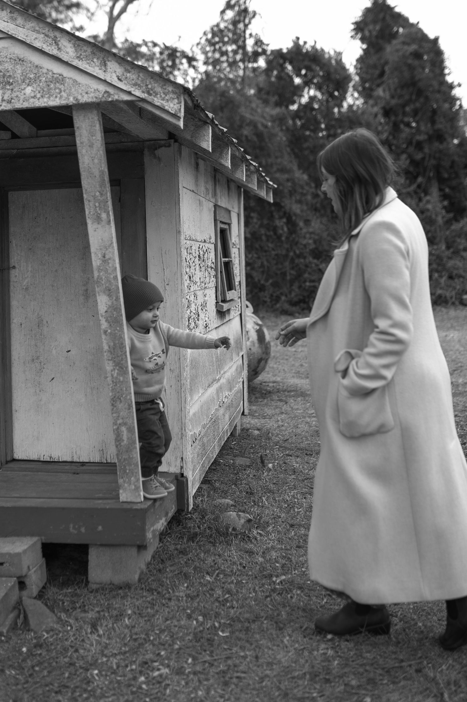 mom and child holding hands near chicken coop