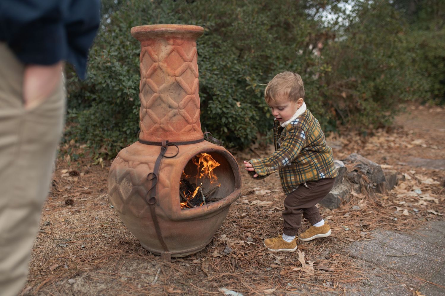 child putting a stick into a wood stove