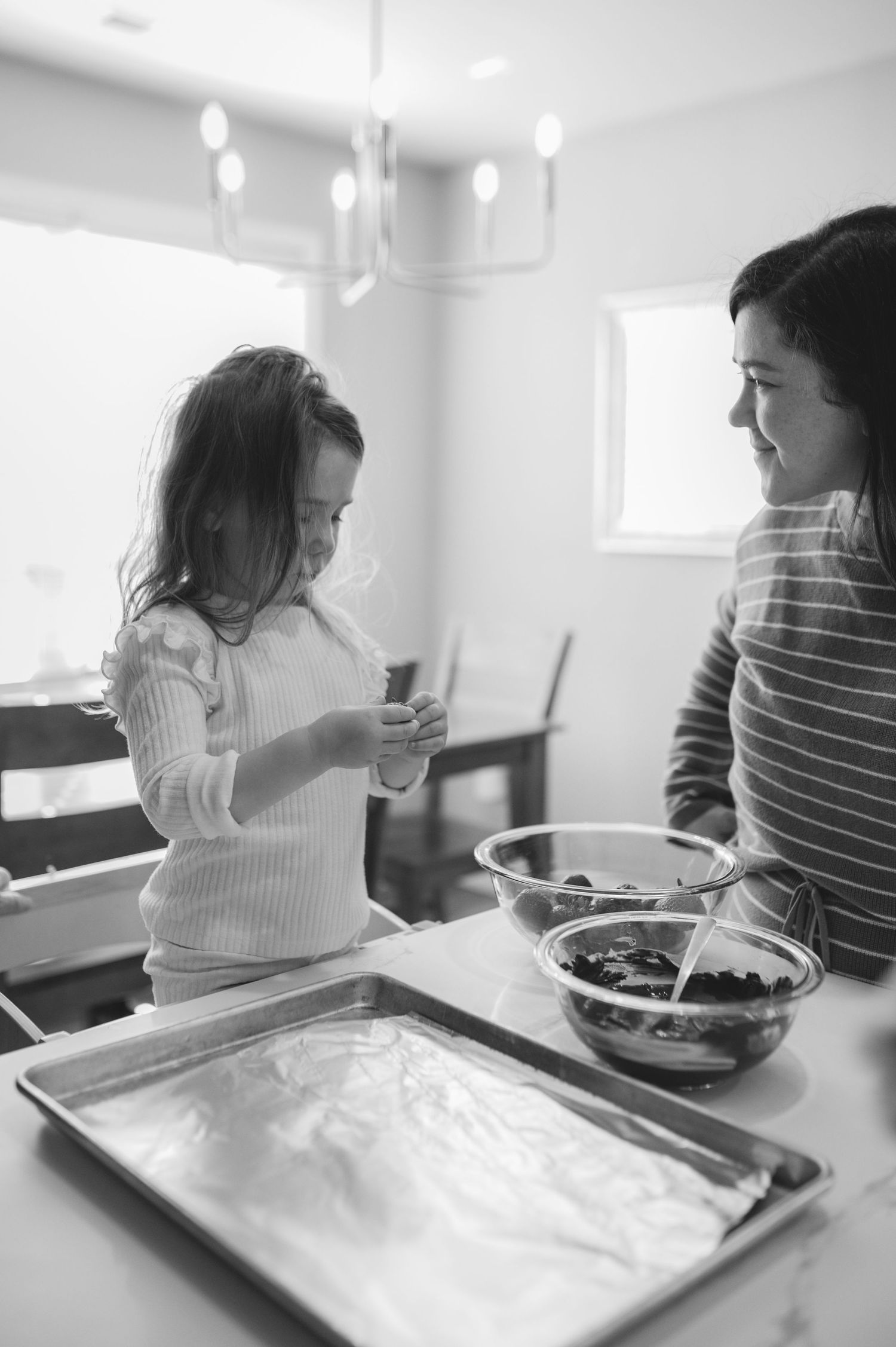 mom and child with baking tray and bowl of strawberries and chocolate, greenville, nc