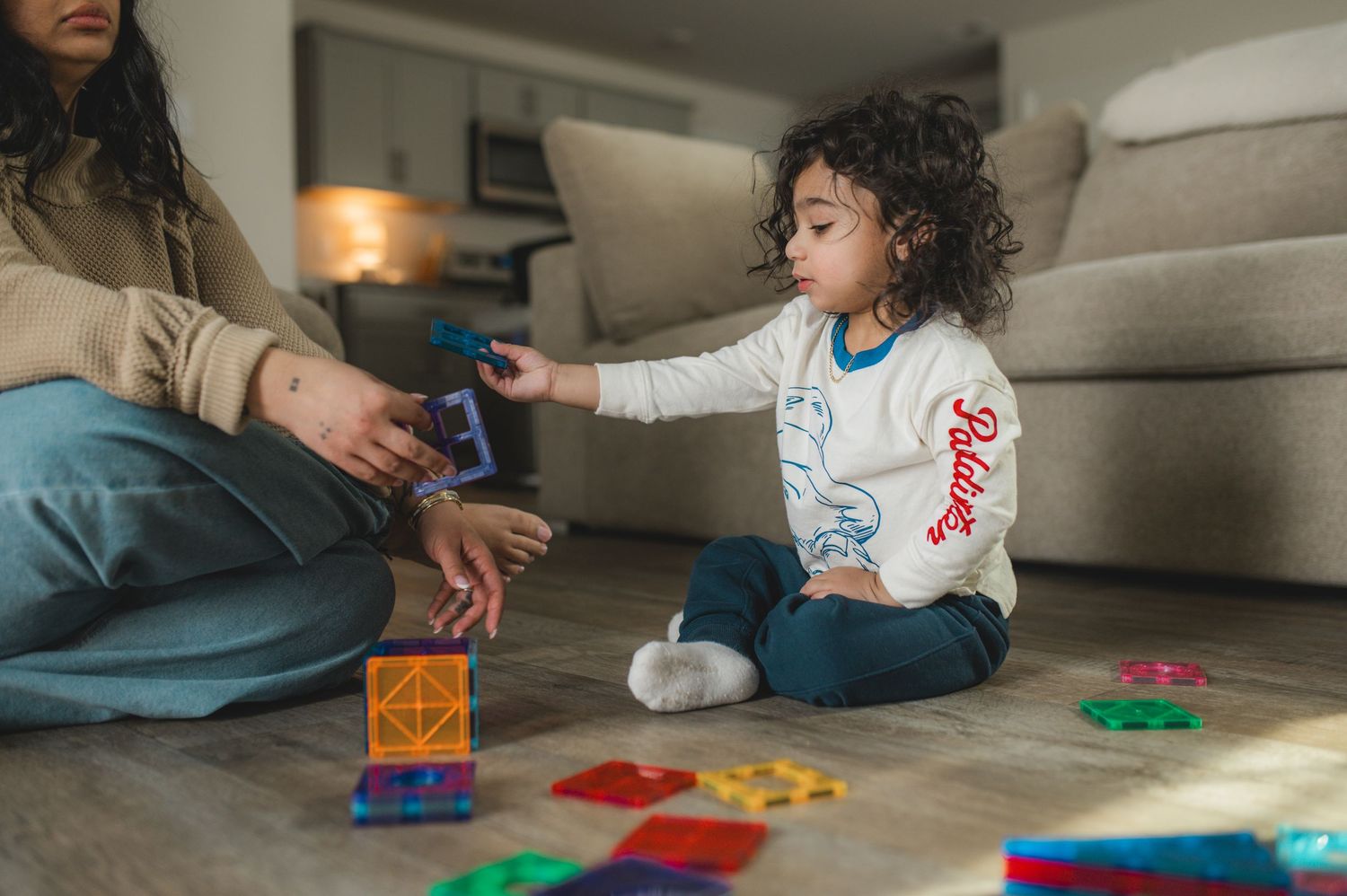 child and mom playing with magna-tiles on floor during at-home family documentary photography session