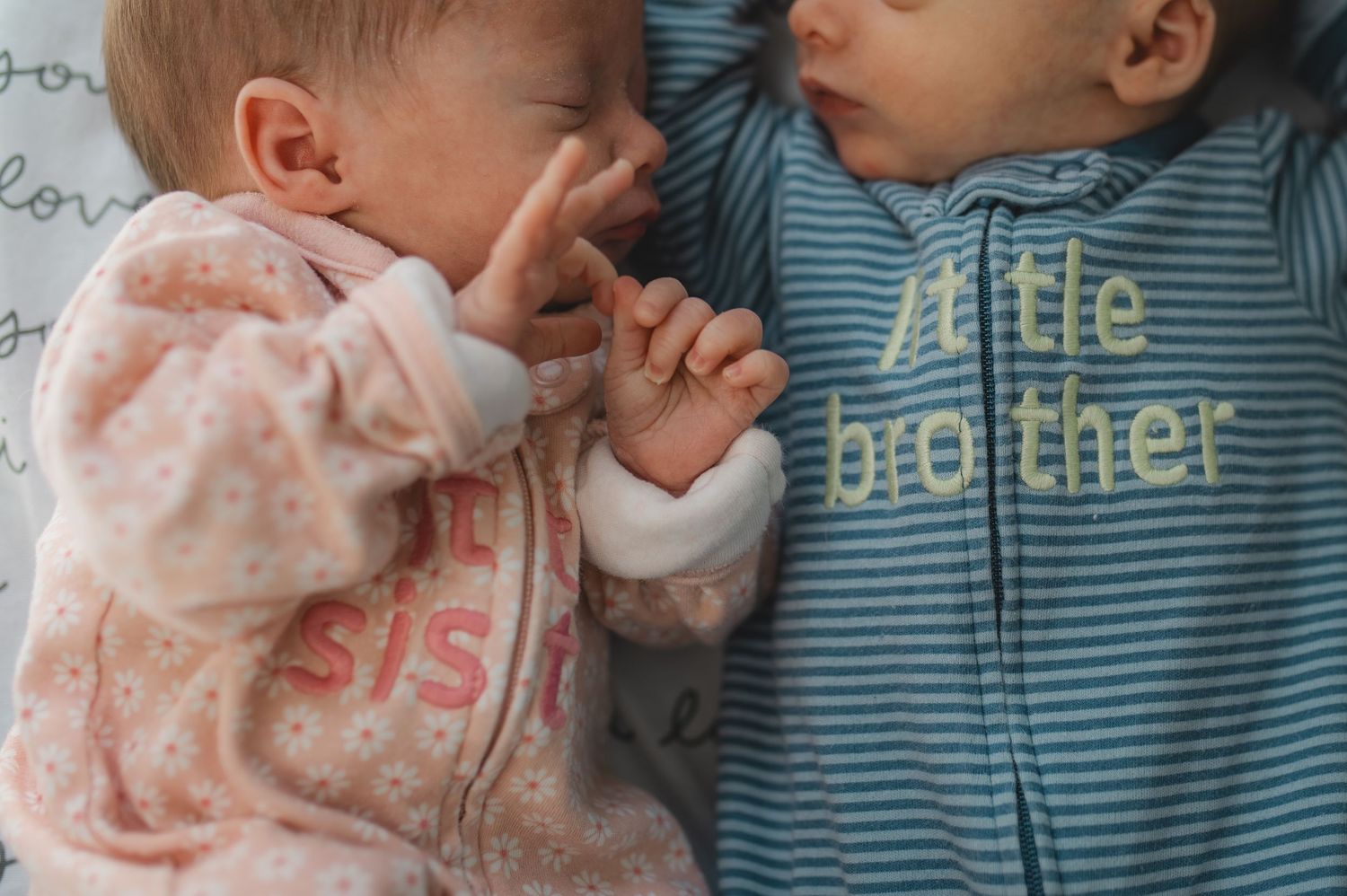 newborn twin boy and girl laying beside each other, little brother, little sister, pink, blue