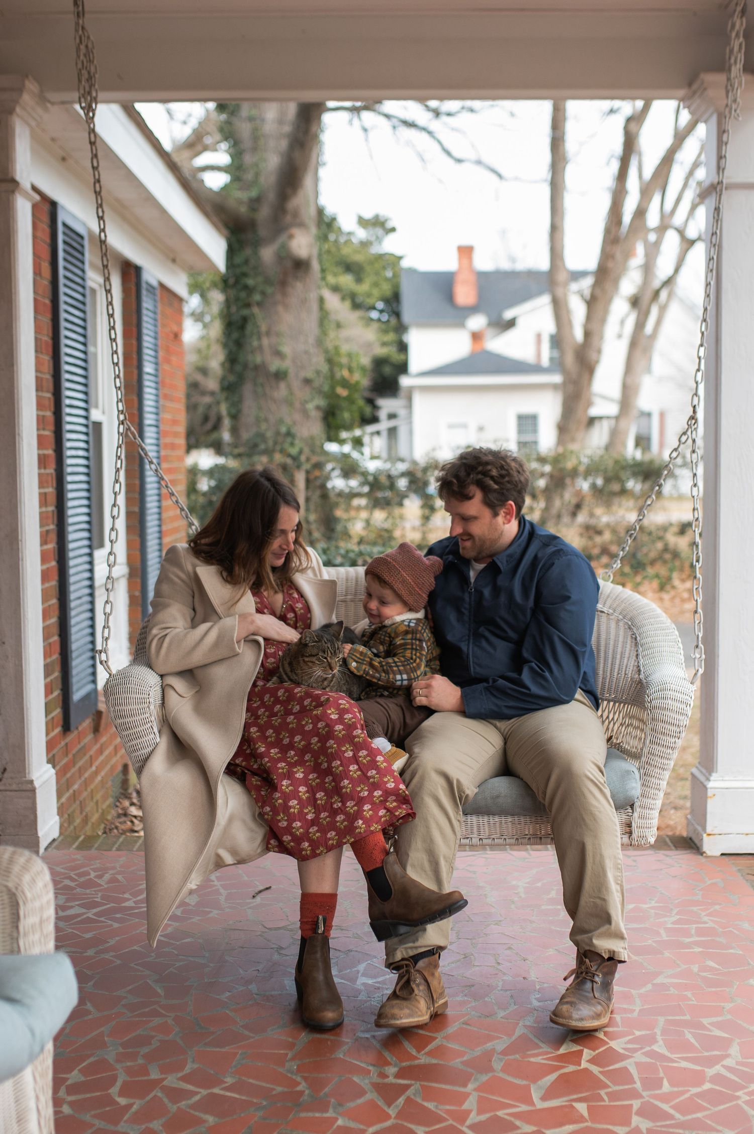 mom dad son, family, sitting on porch swing with cat