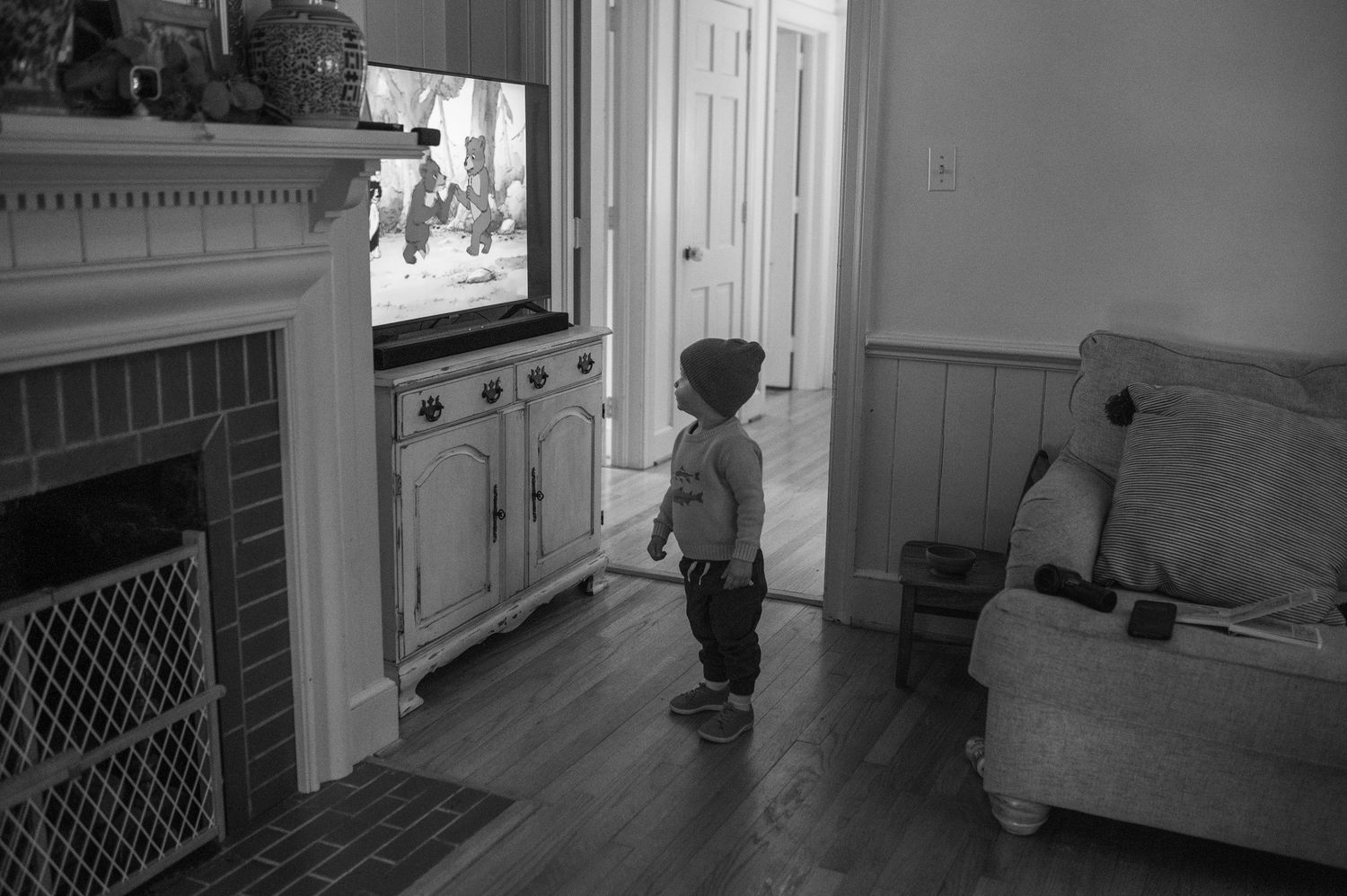 child standing in front of tv with hat on