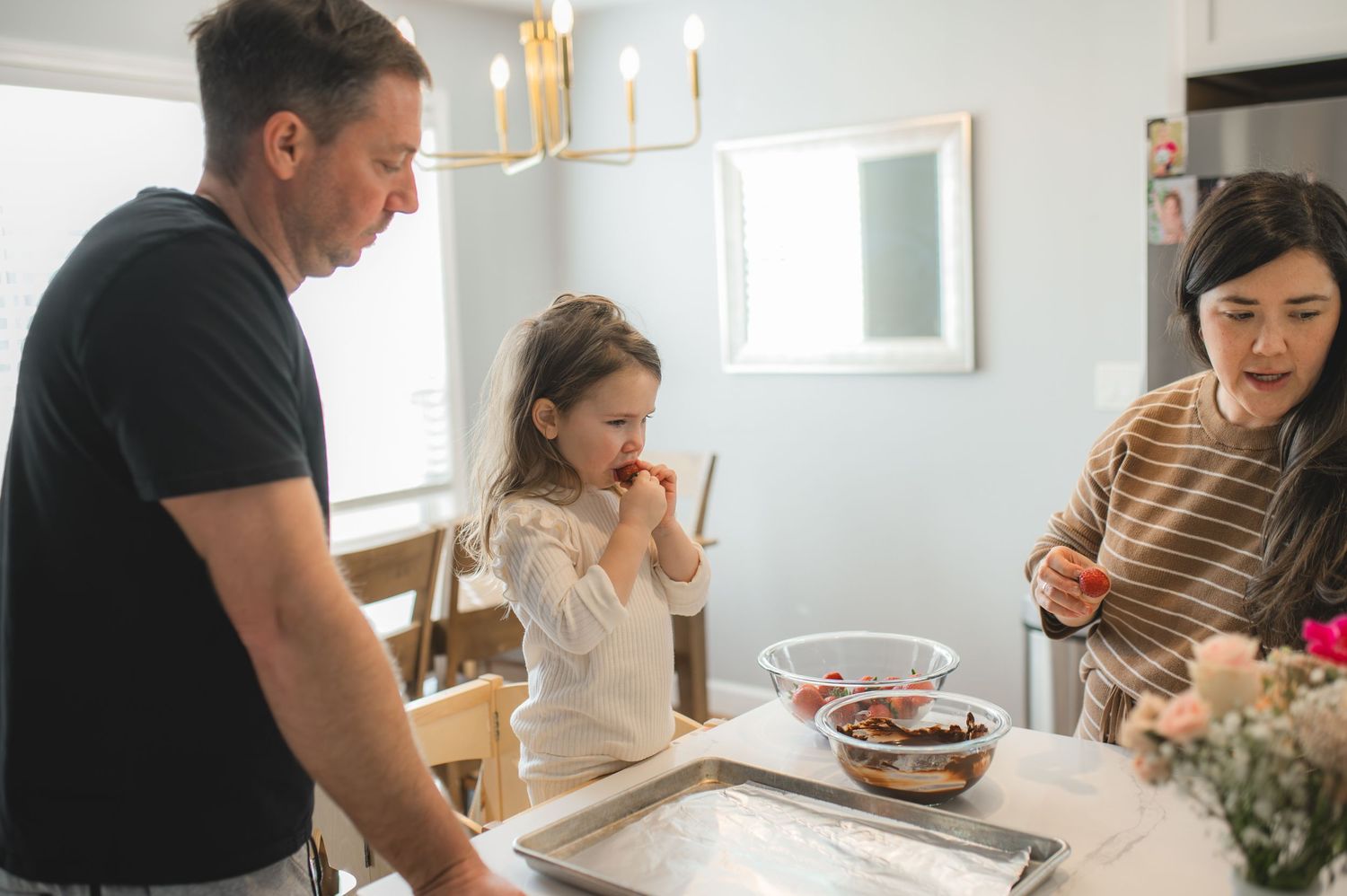 mom dad and child with baking tray and bowl of strawberries and chocolate, greenville, nc