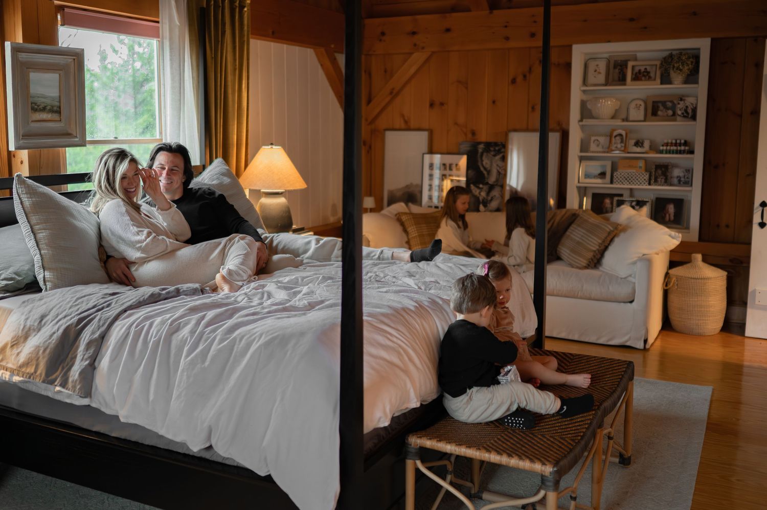 children playing running climbing on bed in parents bedroom, at-home documentary family session mom dad laughing eating snacks
