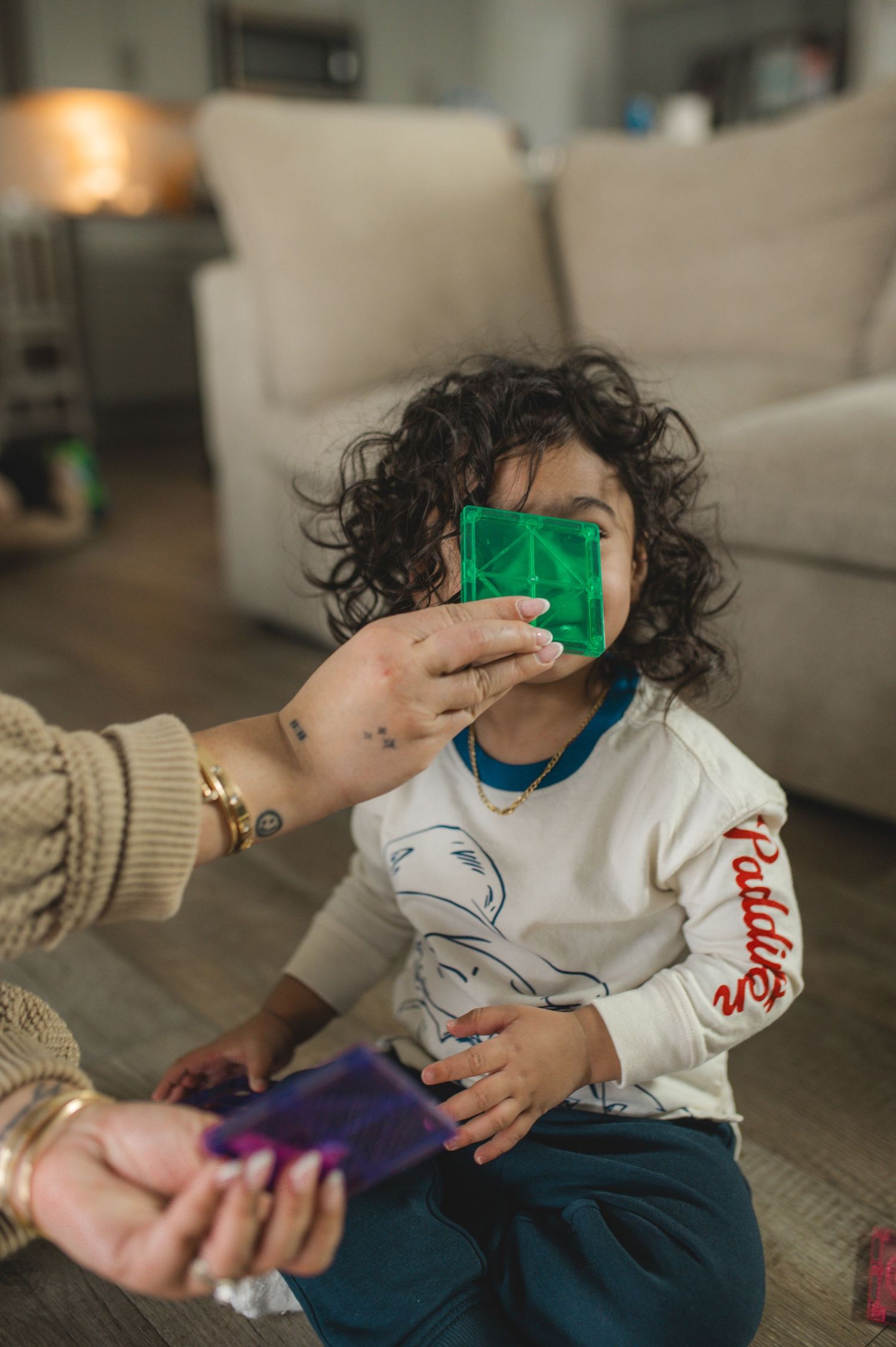child and mom playing with magna-tiles on floor during at-home family documentary photography session