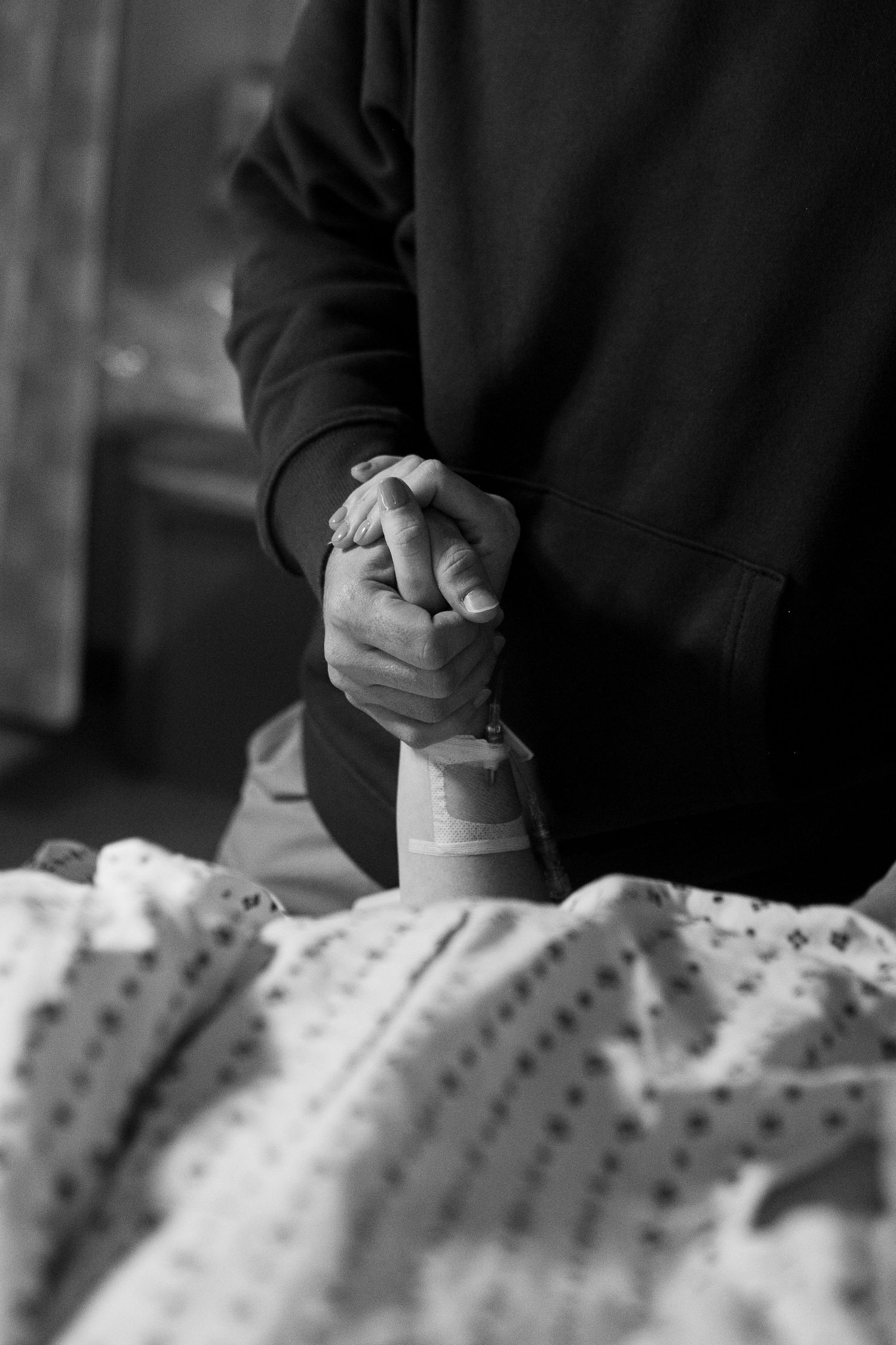 mom and dad holding hands during birth at ECU Health Medical Center in Greenville NC. Birth photographer. black and white.