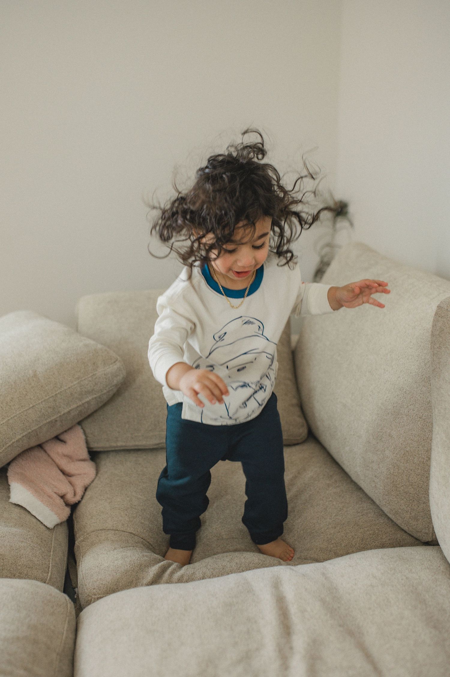 mom dad son, playing on couch with cushions, family at home family photography session, documentary family session, jumping, curly hair