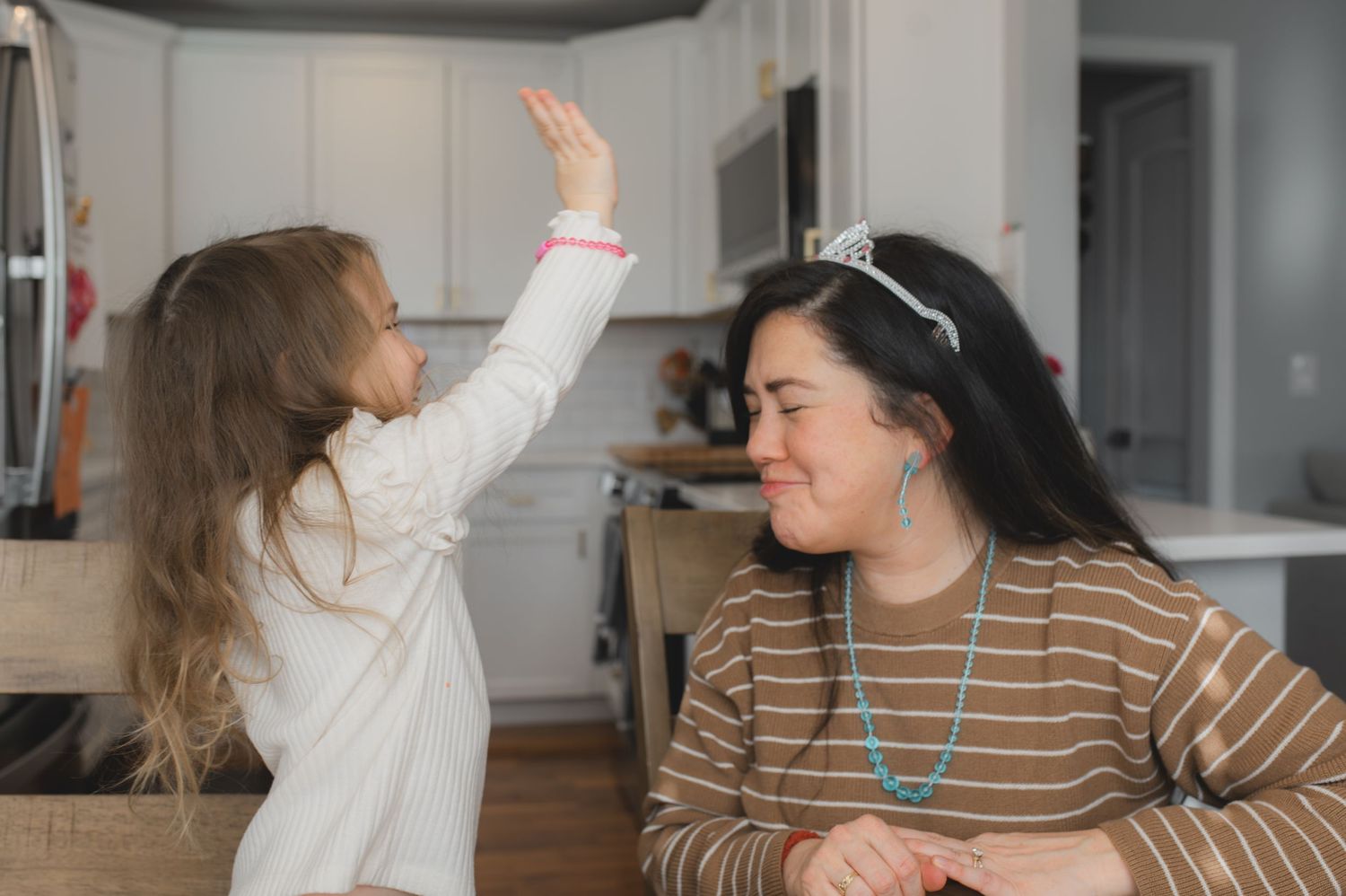 mom and child wearing tiara for board game, laughing, greenville, nc