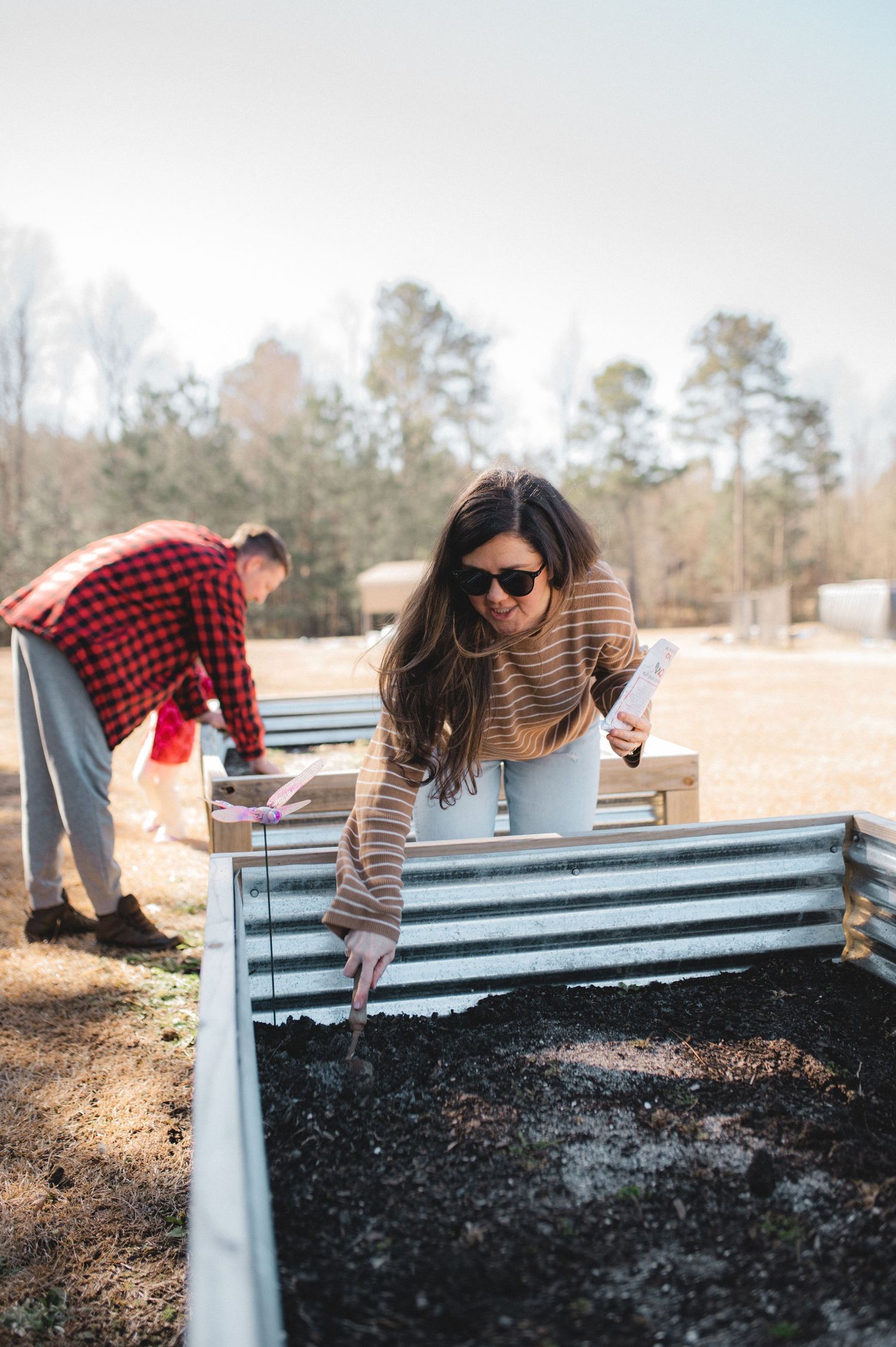 mom planting seeds in raised garden bed, greenville, nc