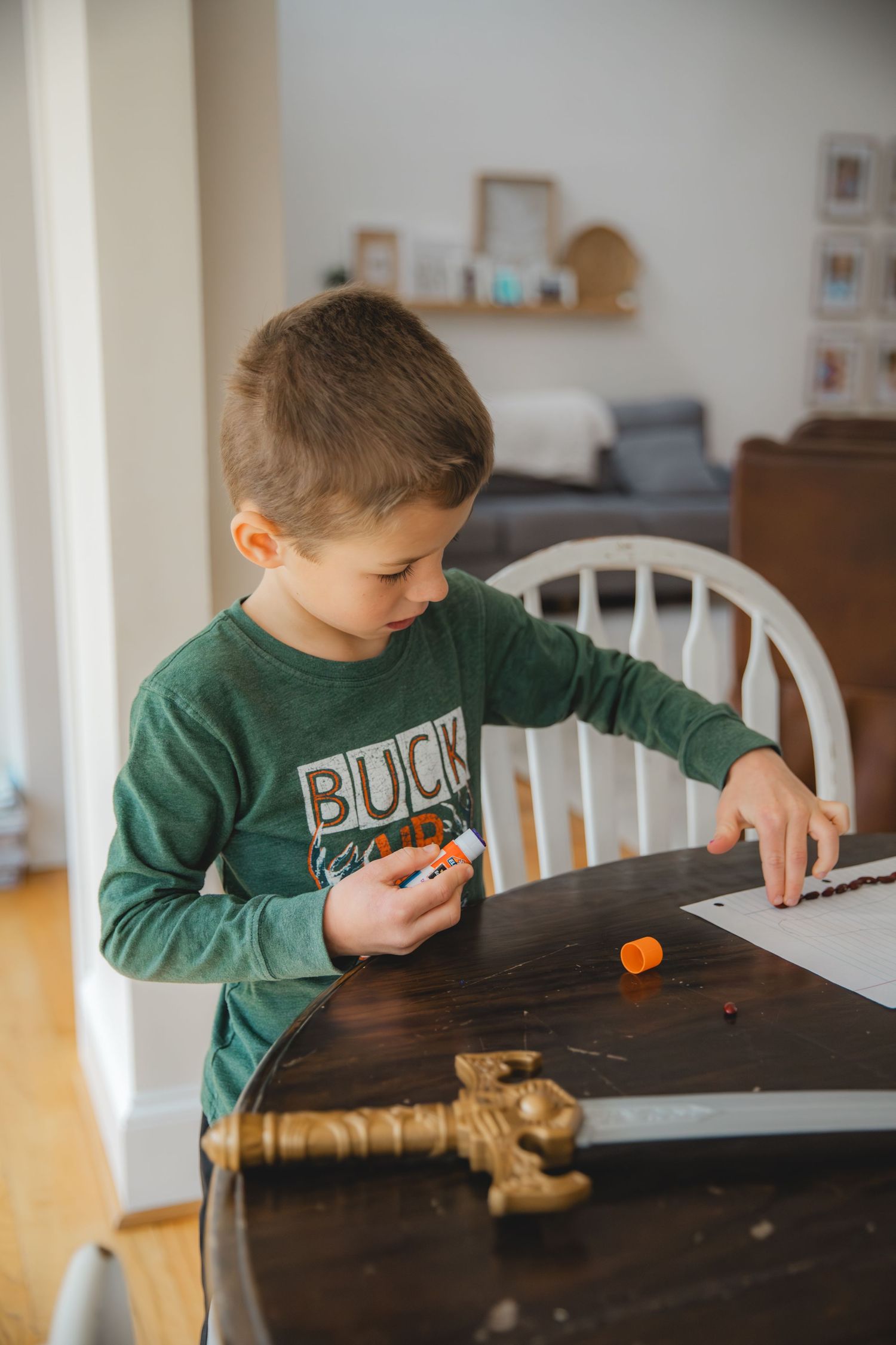 child holding a glue stick and beans
