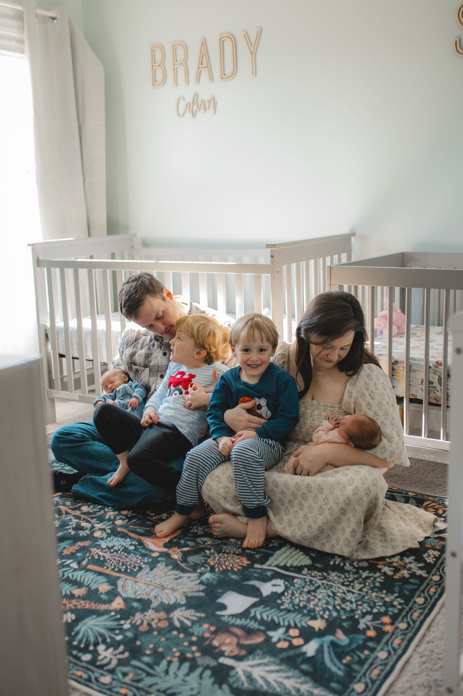 family sitting in front of crib in twin nursery, newborn twins, 3 year old twins, 4 under 4, big brother, little sister, little brother