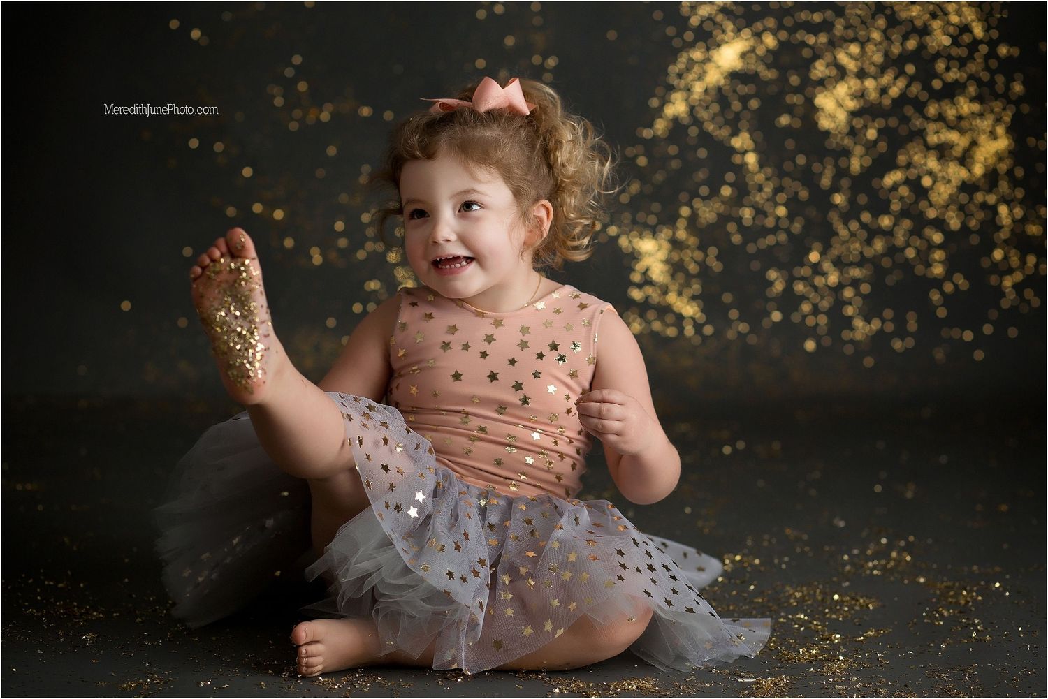A magical portrait featuring sparkly glitter and a tulle dress against a dark background.