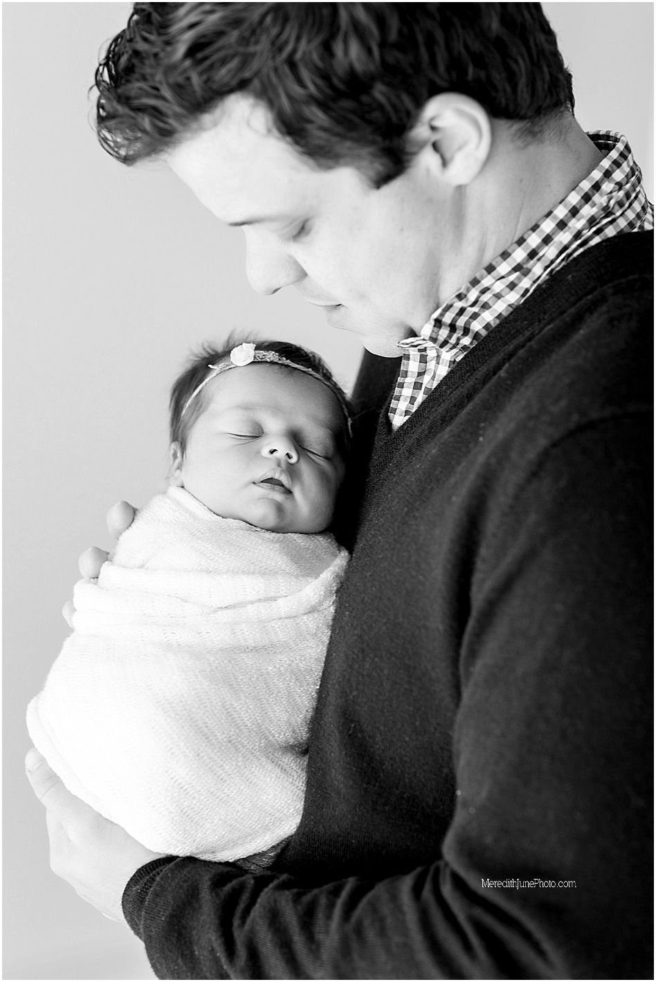 A tender black and white photo series showing a parent cradling and bonding with their sleeping newborn baby.