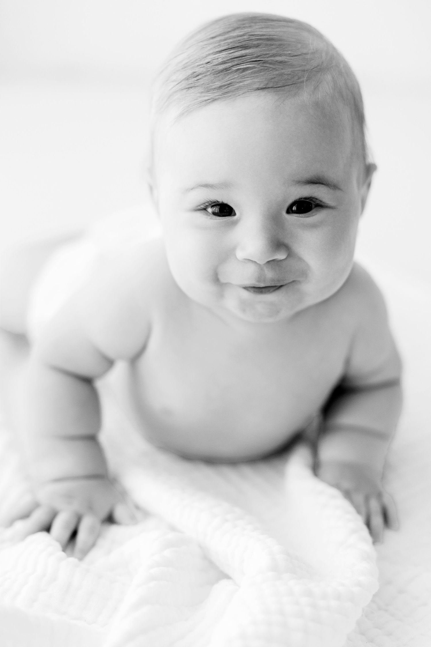 High-key portrait series of baby on white background showing various sweet expressions.