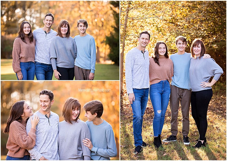 A group poses together in coordinated blue and pink outfits against a backdrop of golden autumn foliage.