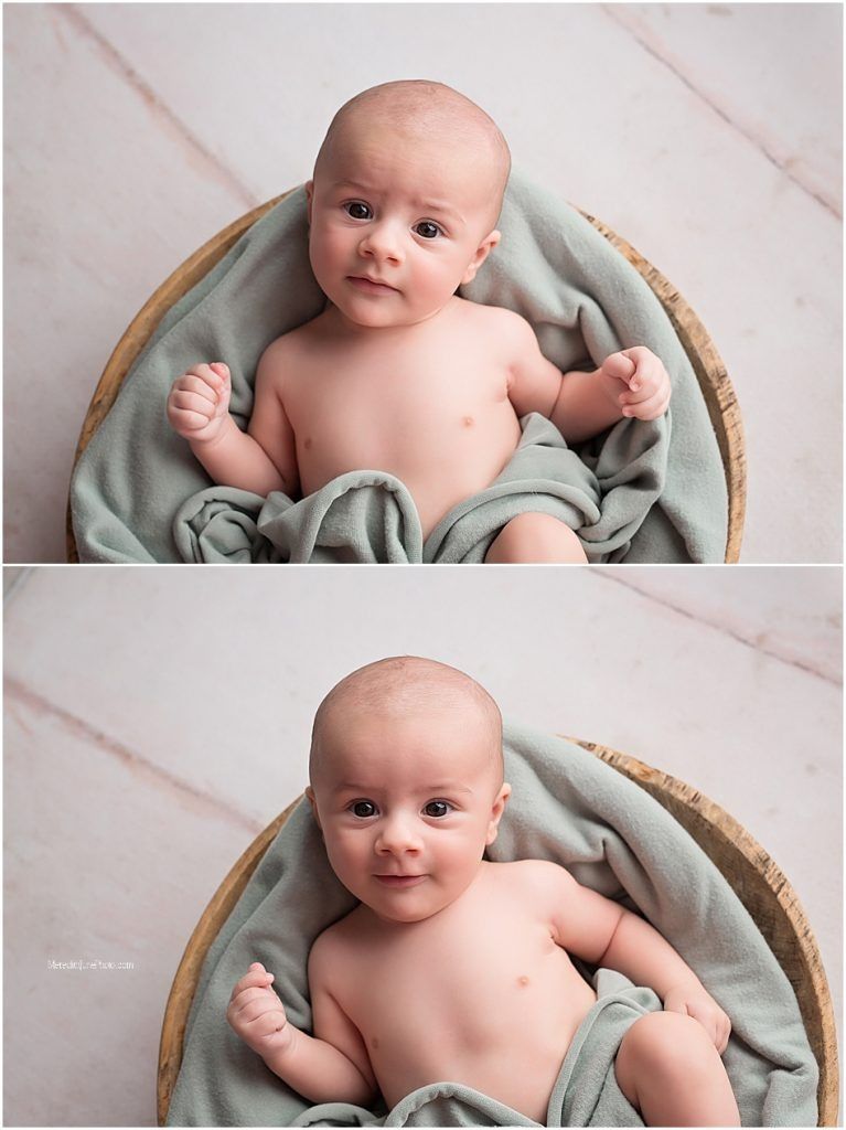 A baby lies in a woven basket with soft mint green fabric creating a cozy newborn photography setup.