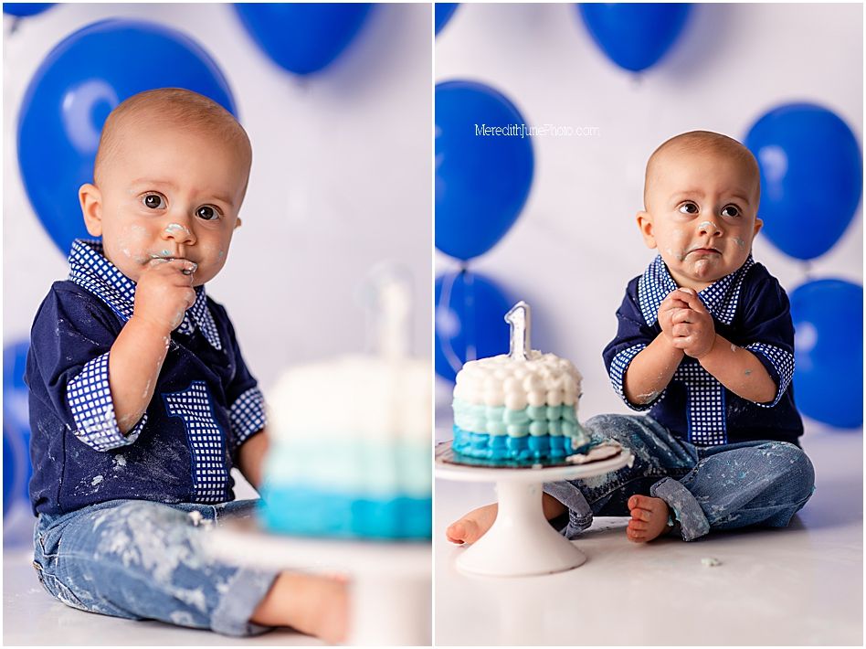 A baby in blue and white stripes crawls near a turquoise cake with blue balloons in the background.