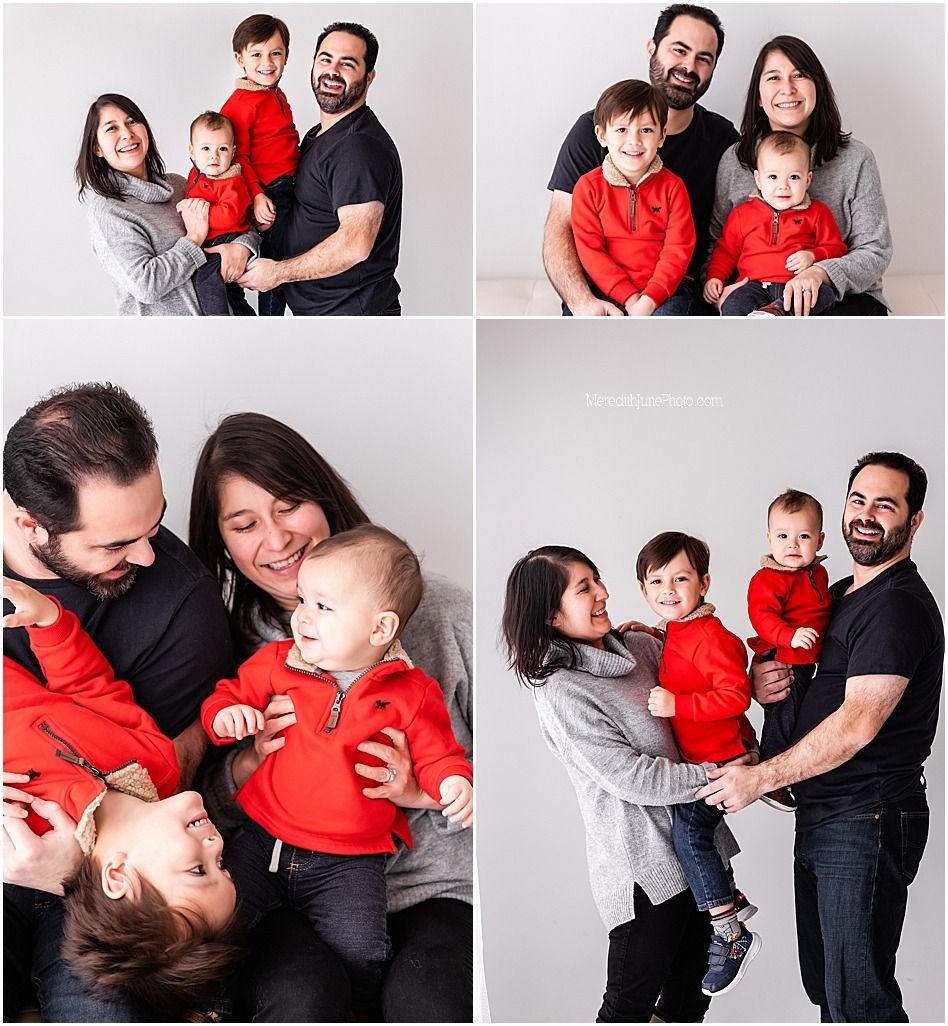 A family wearing red and black outfits poses together for casual portrait photos in a studio setting.