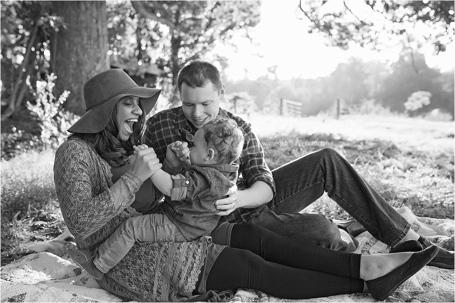 A series of black and white romantic photos showing a couple lying in grass together during an outdoor photo session.