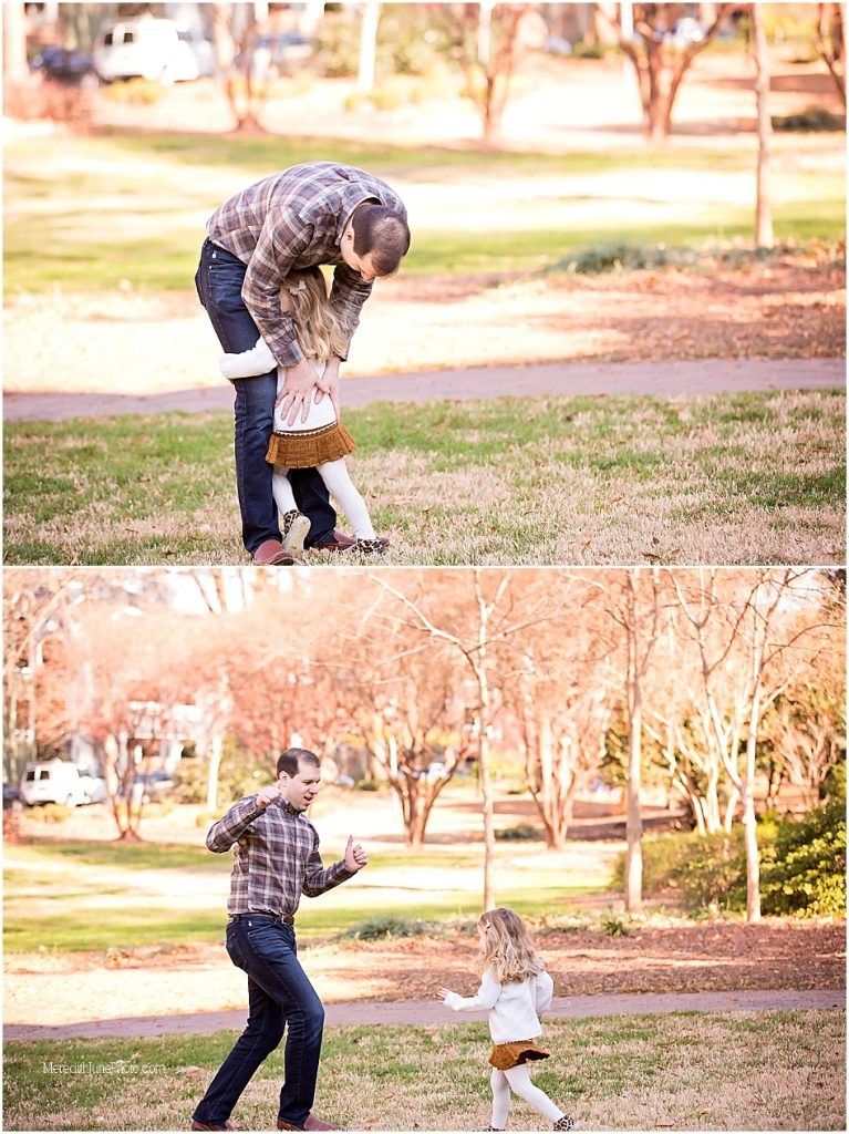 A playful game of chase unfolds between two children and a small dog in a sunlit park.