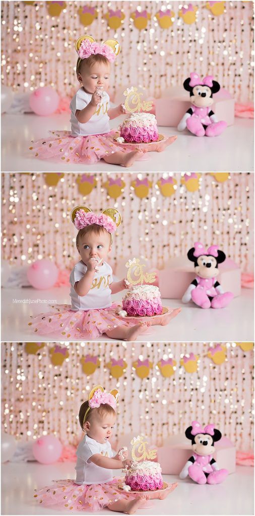 Pink and gold cake smash photo session setup with Minnie Mouse plush toy and sparkly decorations for first birthday celebration.