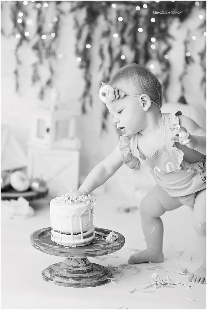 Black and white photos of a baby's first birthday cake smash session showing pure joy and messy cake eating.