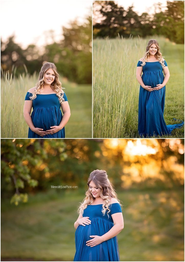 A maternity photoshoot in a grassy field at golden hour featuring a woman in a flowing navy blue dress.