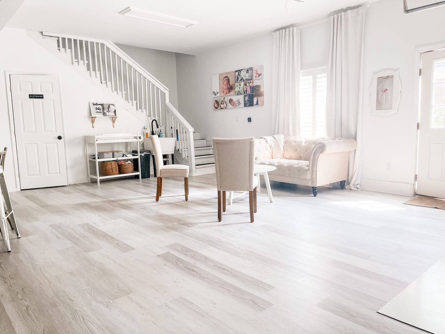 A panoramic view of a bright modern interior with light wood flooring and white walls in a minimalist style.