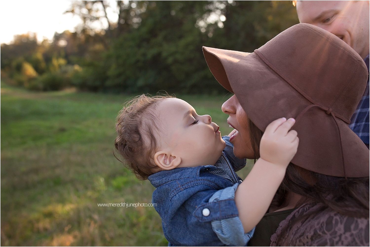 A playful outdoor family photoshoot captured during golden hour with warm autumn lighting.