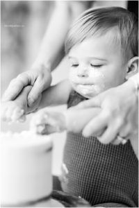 A sequence of black and white photos showing a sleeping baby being gently caressed on the cheek.