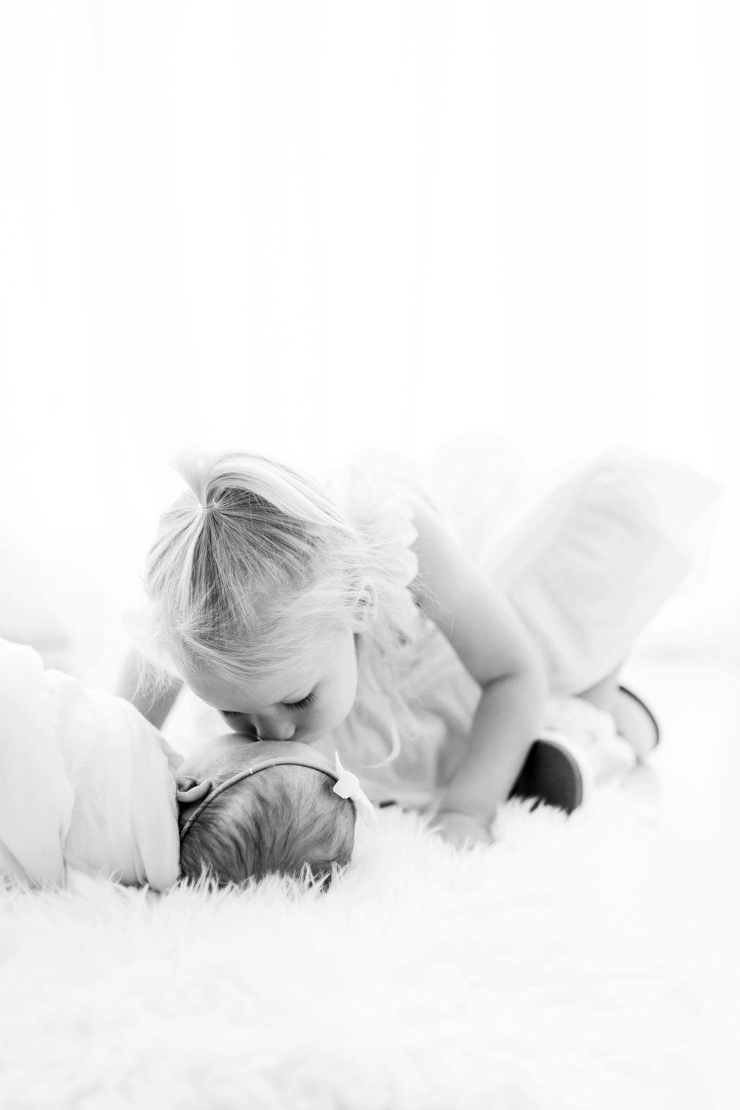 Artistic black and white series of siblings sharing gentle kisses.