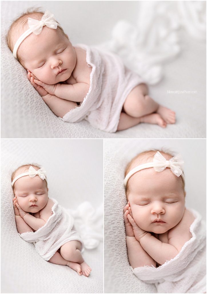 Peaceful newborn baby sleeping on soft white blanket with delicate bow headband in professional studio portrait.