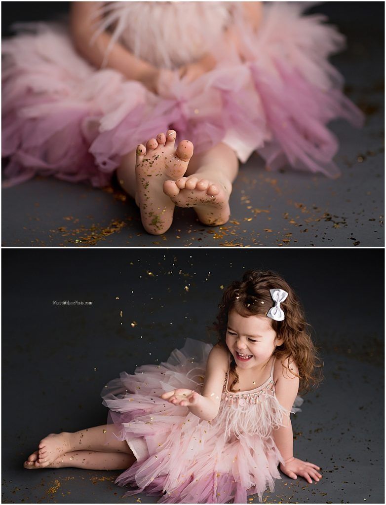 Dreamy pink tulle dress photoshoot with glitter scattered on dark floor creating magical atmosphere.