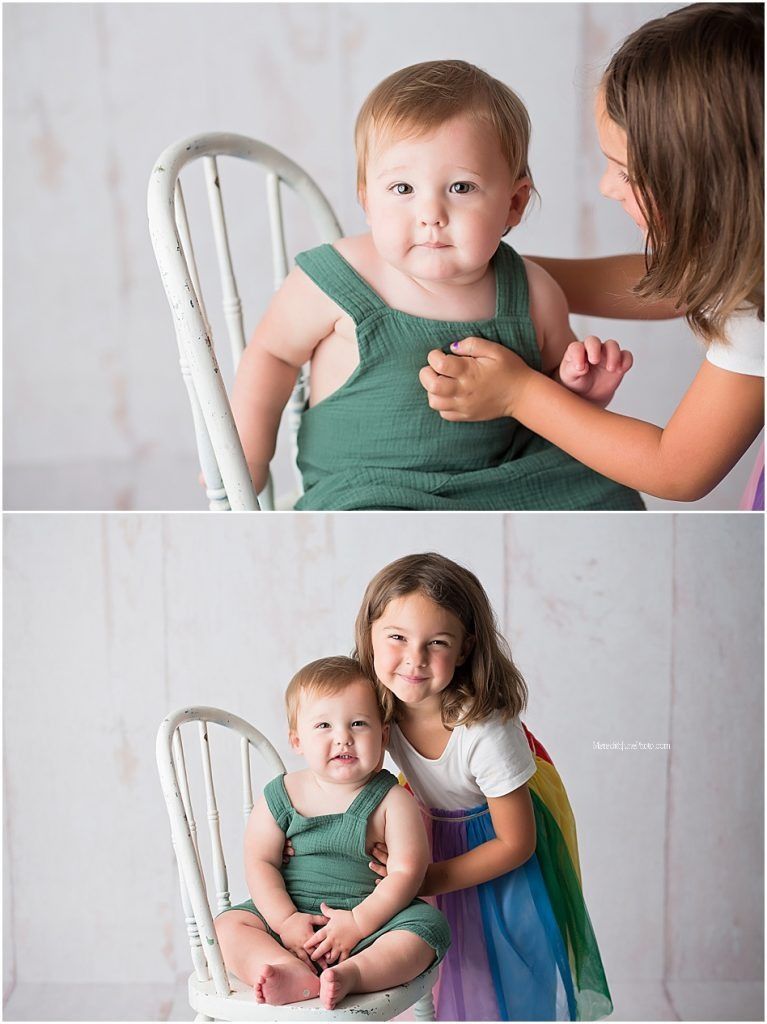Sweet family photo session with siblings and baby against white backdrop.