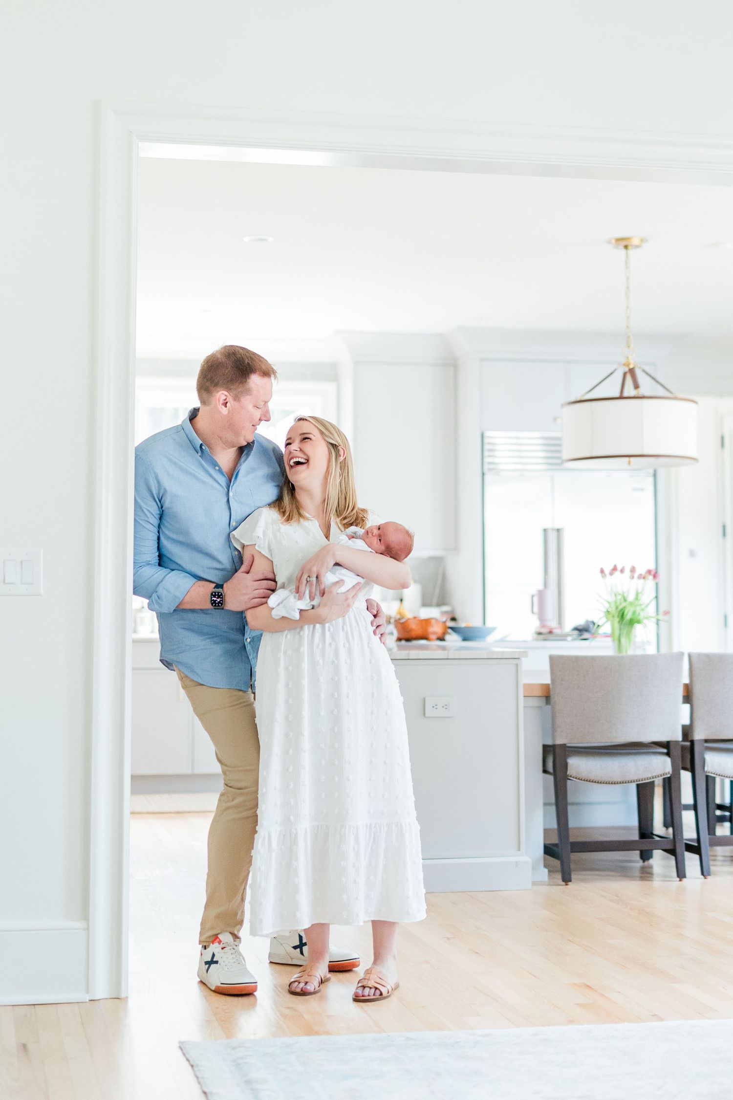 Series of joyful moments between a couple dancing and laughing together in a bright white kitchen space.